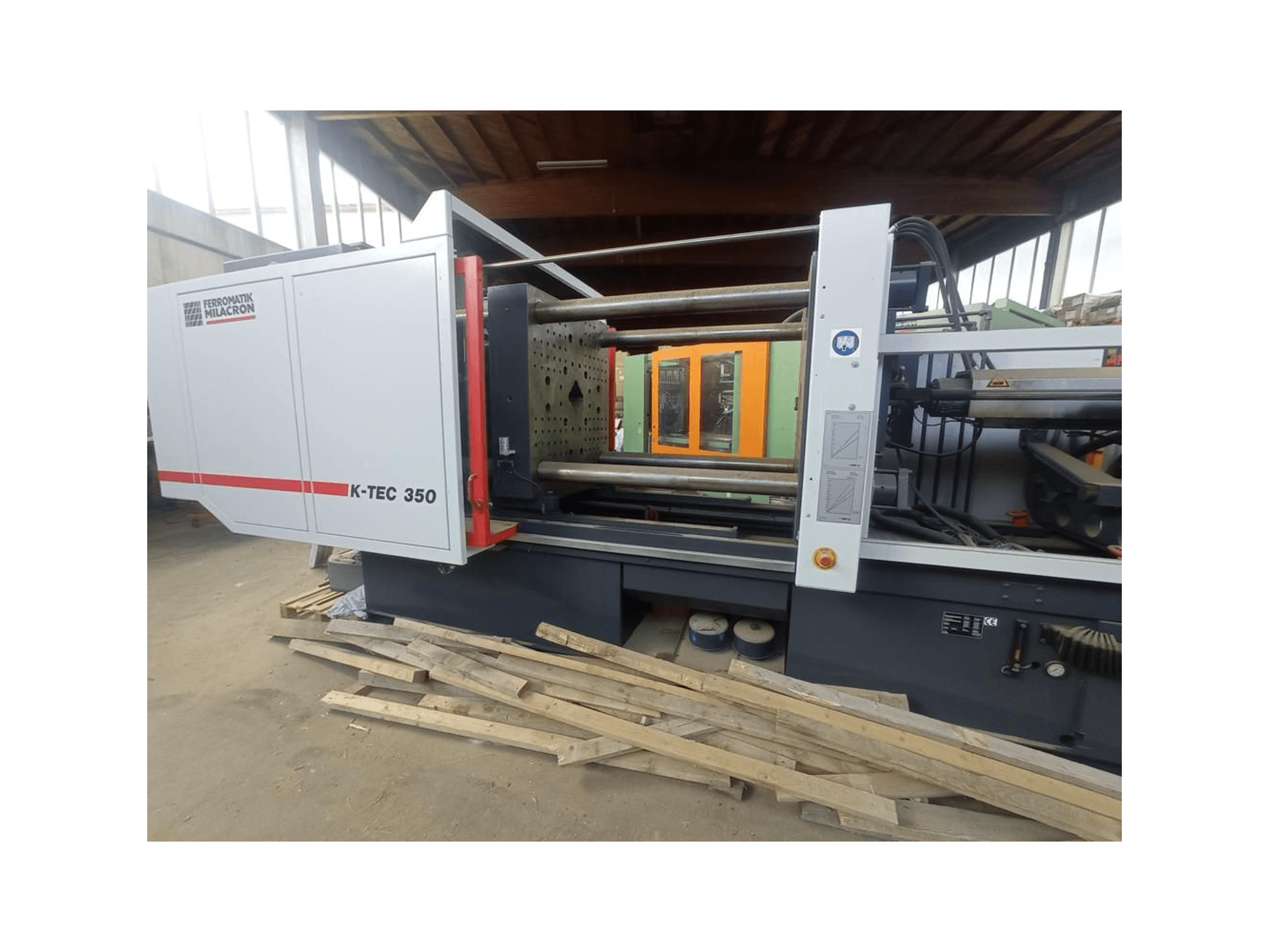 K-TEC 350 von Ferromatik Milacron, von der Seite betrachtet, mit seinen komplexen Maschinen und Bedienelementen.