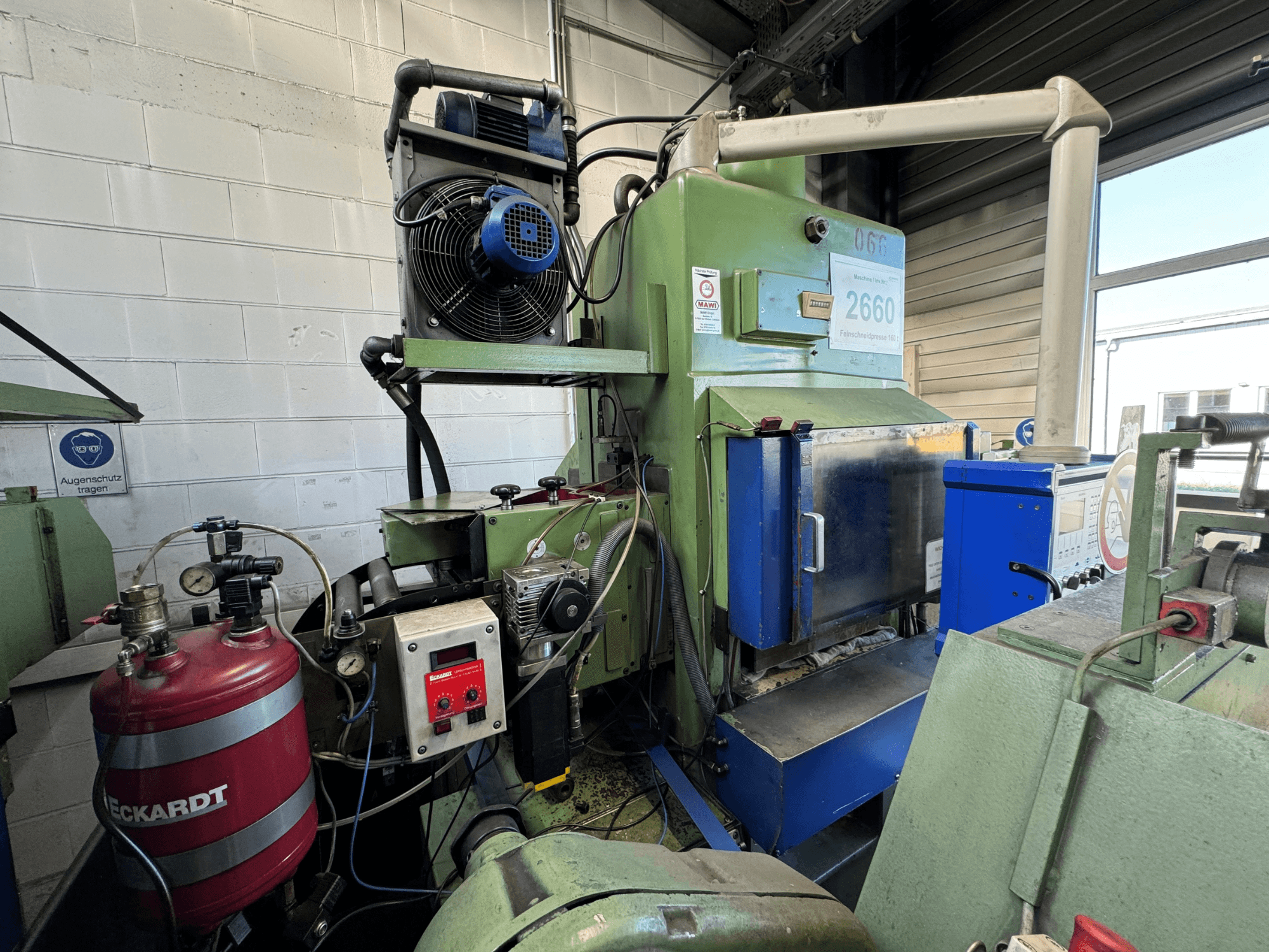Grüne Industriemaschine mit blauer Schalttafel, Ventilator, Drehreglern und einem roten Tank mit der Aufschrift "ECKARDT", Vorderansicht.